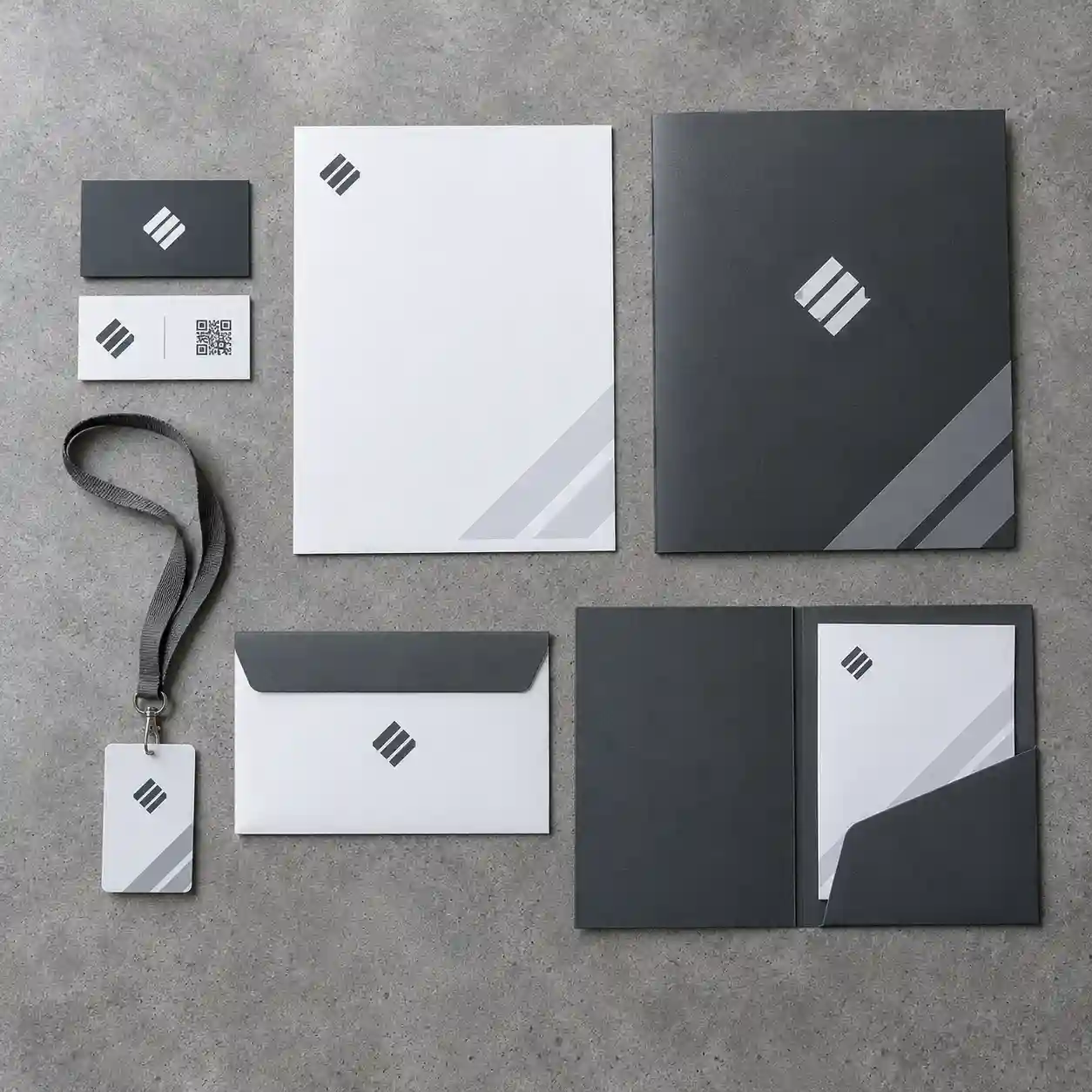 Papelería institucional con tarjetas QR, hoja membretada y carpeta corporativa en CDMX Vista cenital de tarjetas de presentación con código QR, hoja membretada, sobre, carpeta corporativa y credencial en gris grafito sobre concreto pulido